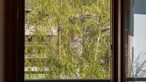 A window with a view of a tree and buildings. - Palú Elf Den in the heart of Aprica (Aprica)