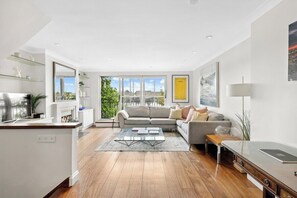 Ein modernes Wohnzimmer mit einer Couch, einem Couchtisch und Blick ins Freie.