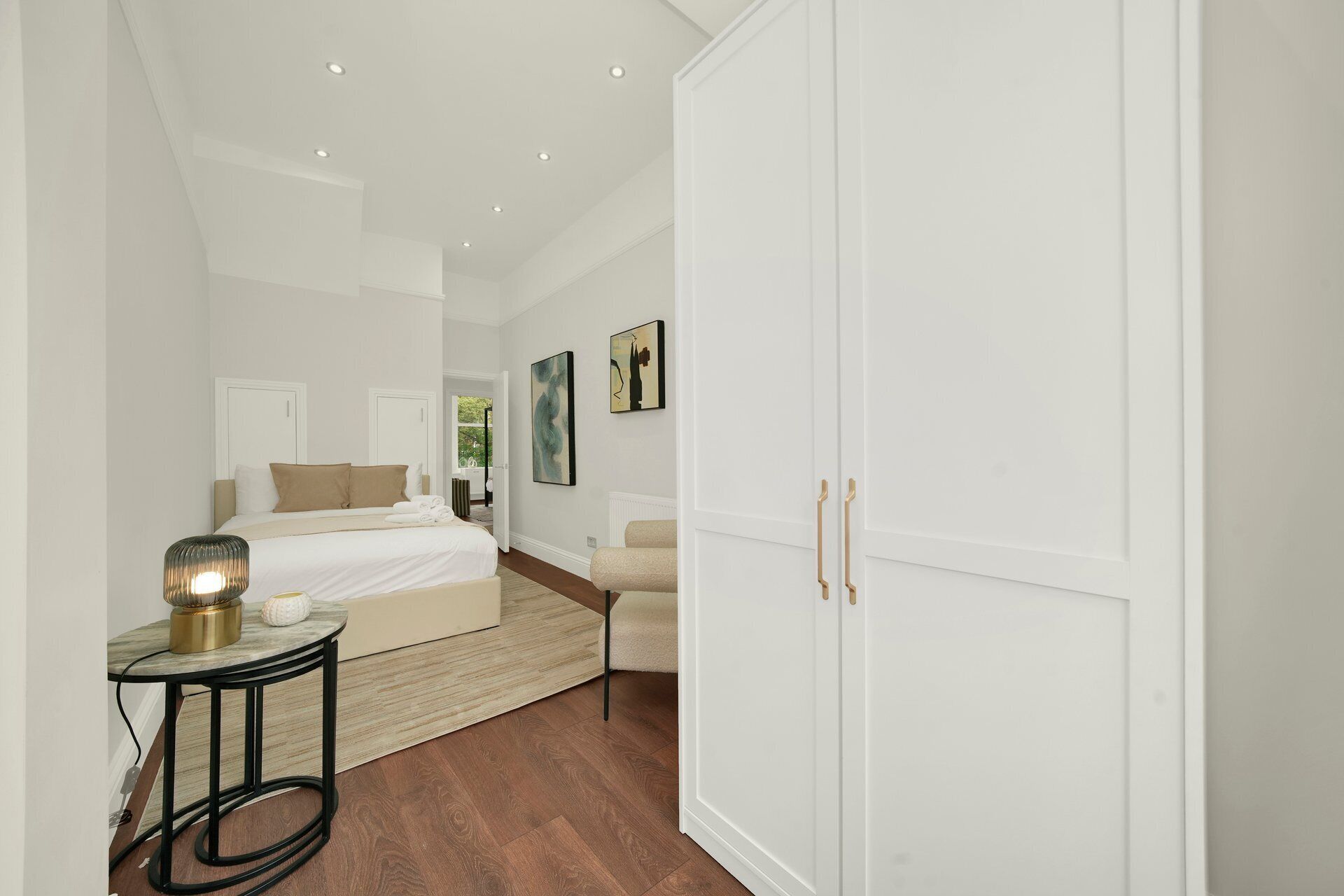 A bedroom with a bed, bedside table, and wardrobe.