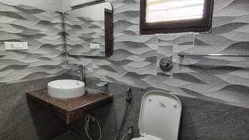 A bathroom with a toilet, sink, and mirror.