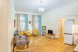 Ein kompakter Wohnraum mit Essbereich, einer Küche und einem Fernseher.