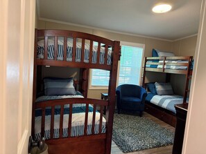 A room with two bunk beds, a chair, and a window with blinds. - Skipper's Cove, Lakefront Family Escape w/ Private Dock, Kayaks, Fire Pit & more (Lexington)