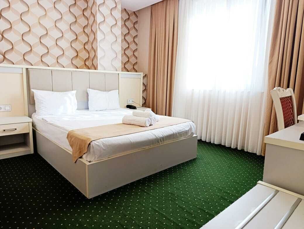 Une chambre d’hôtel avec un lit, une table de chevet et un bureau.