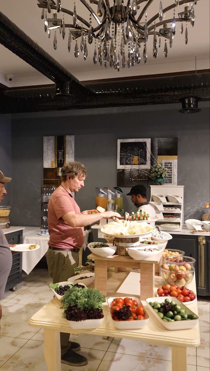 A buffet setup with various food items and a chandelier.
