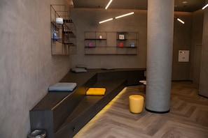 A modern interior with a long counter, a large pillar, and a wall-mounted shelf with various items. - Luxury studio apartment in Vila Olímpia - panoramic view and garage. (São Paulo)