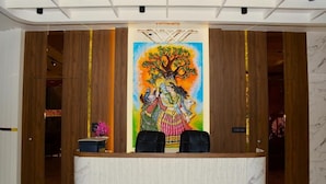A reception desk with a mural, wooden paneling, and a marble floor. - Foxoso Fiori Khatu Shyam (Danta Ramgarh)