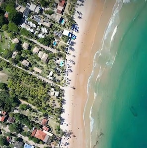 An aerial view of a coastal area with buildings, a beach, and a clear sky. - Modern Ground Floor Beachfront Studio: Smart Economy (Maraú)
