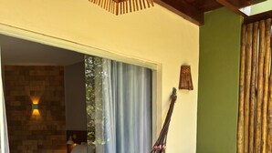 A room with a bed, a hammock, a wooden chair, and a wall-mounted lamp. - Modern Ground Floor Beachfront Studio: Smart Economy (Maraú)