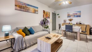 Uma sala de estar moderna com sofá, mesa de centro e área de jantar.