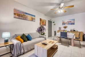 Een moderne woonkamer met een bank, salontafel en eethoek.