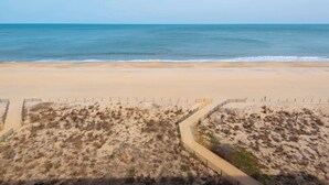 Ein Strand mit einem Sandweg und einem Zaun.