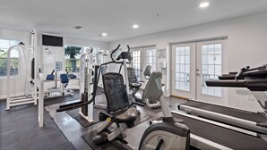 A gym with various exercise equipment, including a treadmill, weight machines, and a bench. - Grand Caribbean 425 by Liquid Life (Orange Beach)