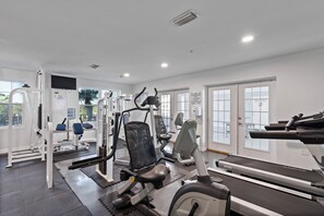 A gym with various exercise equipment, including a treadmill, weight machines, and a bench. - Grand Caribbean 425 by Liquid Life (Orange Beach)