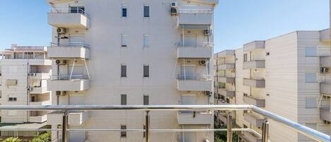 Un edificio residenziale a più piani con balconi, un tetto piano e cielo sereno.