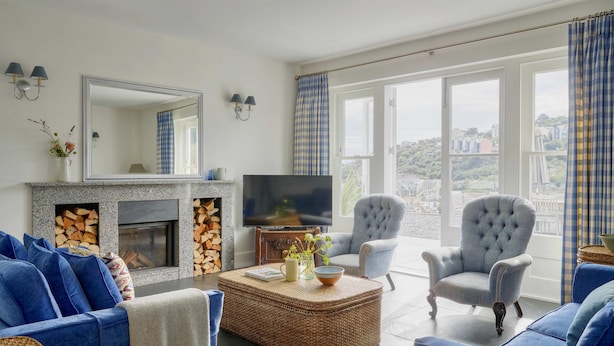 A living room with a fireplace, television, and seating area. - Luxury Coastal Cottage With Harbour Views (St Austell)