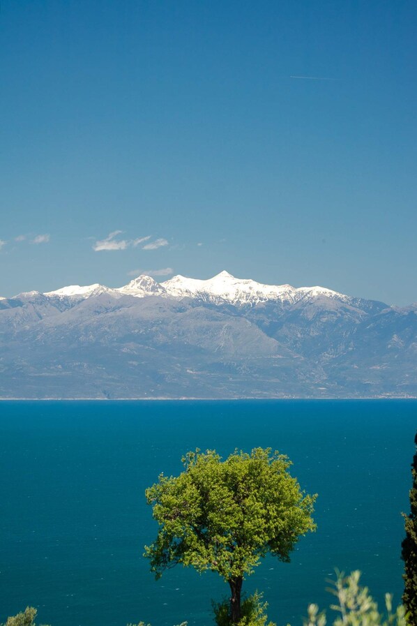 A mountain range with snow-capped peaks and a clear blue sky.