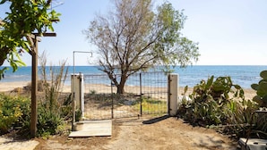 A beach gate with a wooden deck, a metal gate, and a tree in the background. - Sinani Beachfront Gems Rhodes Jacuzzi Retreat (Rhodes)