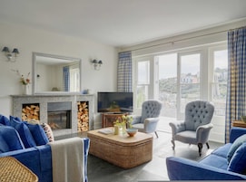 Una sala de estar con chimenea, televisión y zona de estar con vistas.