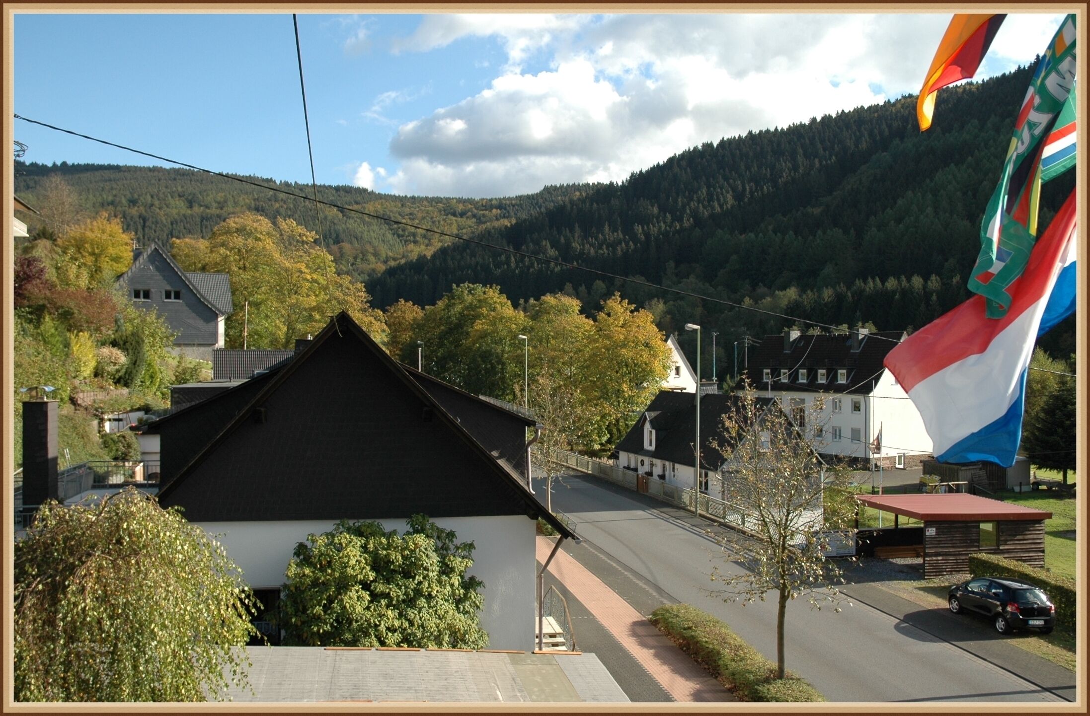 Ein Gebäude mit einem geneigten Dach, einer gepflasterten Straße und einer Flagge.