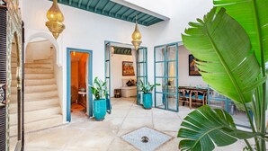 Un intérieur spacieux avec un escalier, des plantes en pot et un coin repas.