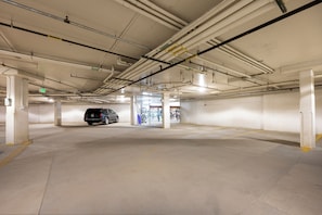An underground parking garage with concrete pillars, a car, and a bicycle rack. - NEW ski-in/ski-out 3 bedroom, private deck, views and plenty of bedding! (Granby)