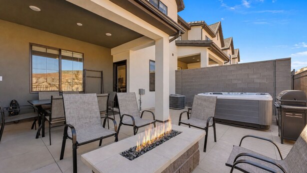 Une terrasse extérieure dotée d’un foyer, de sièges et d’un jacuzzi.