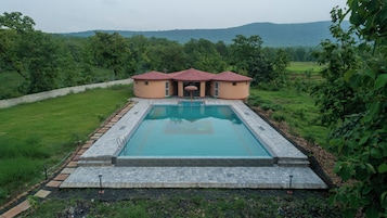 A swimming pool with a red-roofed building in the background.