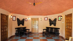 Una habitación con dos puertas de madera, un suelo a cuadros y dos bancos.