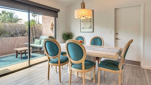 A dining area with a table, chairs, and a hanging light fixture. - 1 Mi to Dtwn Palm Springs! Desert Escape w/ Pool (Palm Springs)