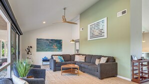A living room with a sofa, coffee table, and a painting on the wall. - 1 Mi to Dtwn Palm Springs! Desert Escape w/ Pool (Palm Springs)