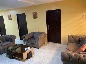 Una sala de estar con dos sofás, una mesa de centro y tres puertas.