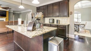 A modern kitchen with dark wood cabinets, granite countertops, and stainless steel appliances. - Spacious Group Hub! Walk to Tribble Mill Park (Lawrenceville)
