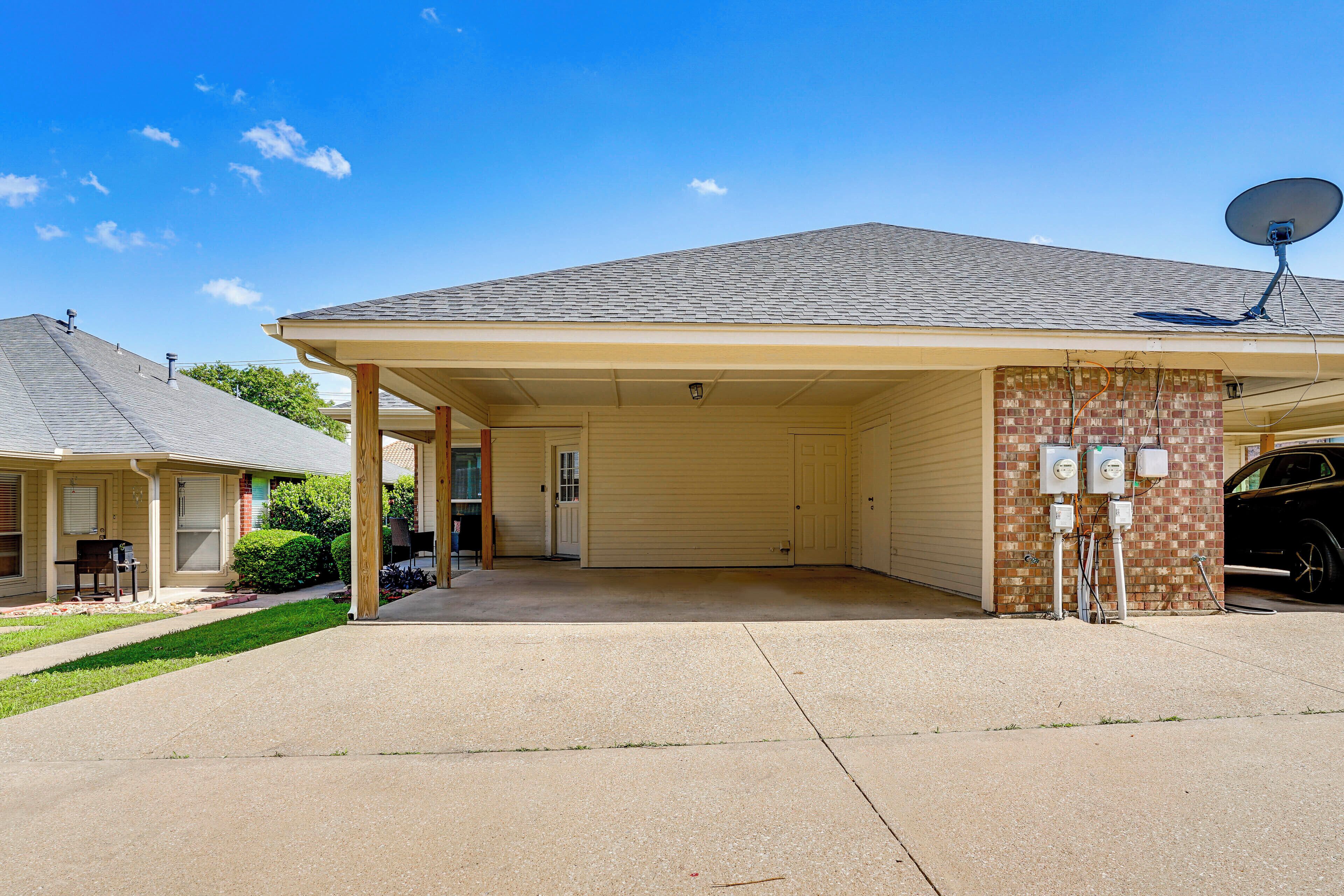 A single-story building with a covered porch, a satellite dish, and a garage.
