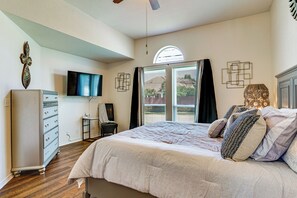 A bedroom with a bed, dresser, TV, and a window with curtains. - Modern Home Near Dfw: Work, Play + Relax! (Mansfield)
