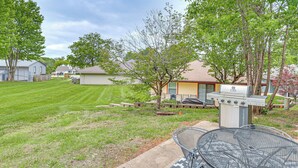 A backyard with a grill, a metal table, and a lawn. - 13 Mi to Kauffman Stadium! 'cottontail Cottage' (Blue Springs)