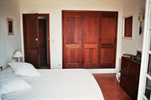 Ein Schlafzimmer mit Bett, Kleiderschrank, Kommode und Spiegel.