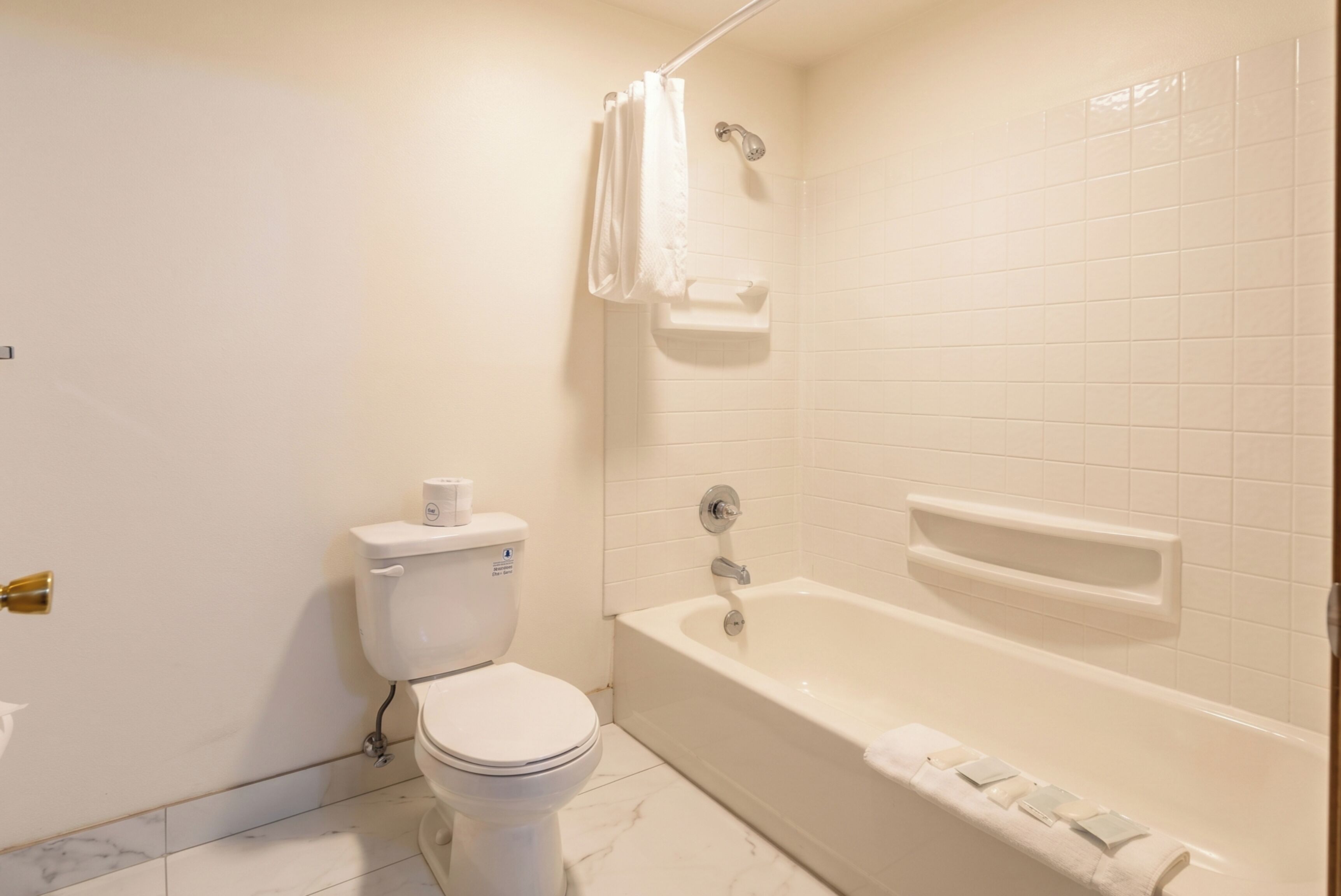 A bathroom with a toilet, a bathtub, and a shower curtain.