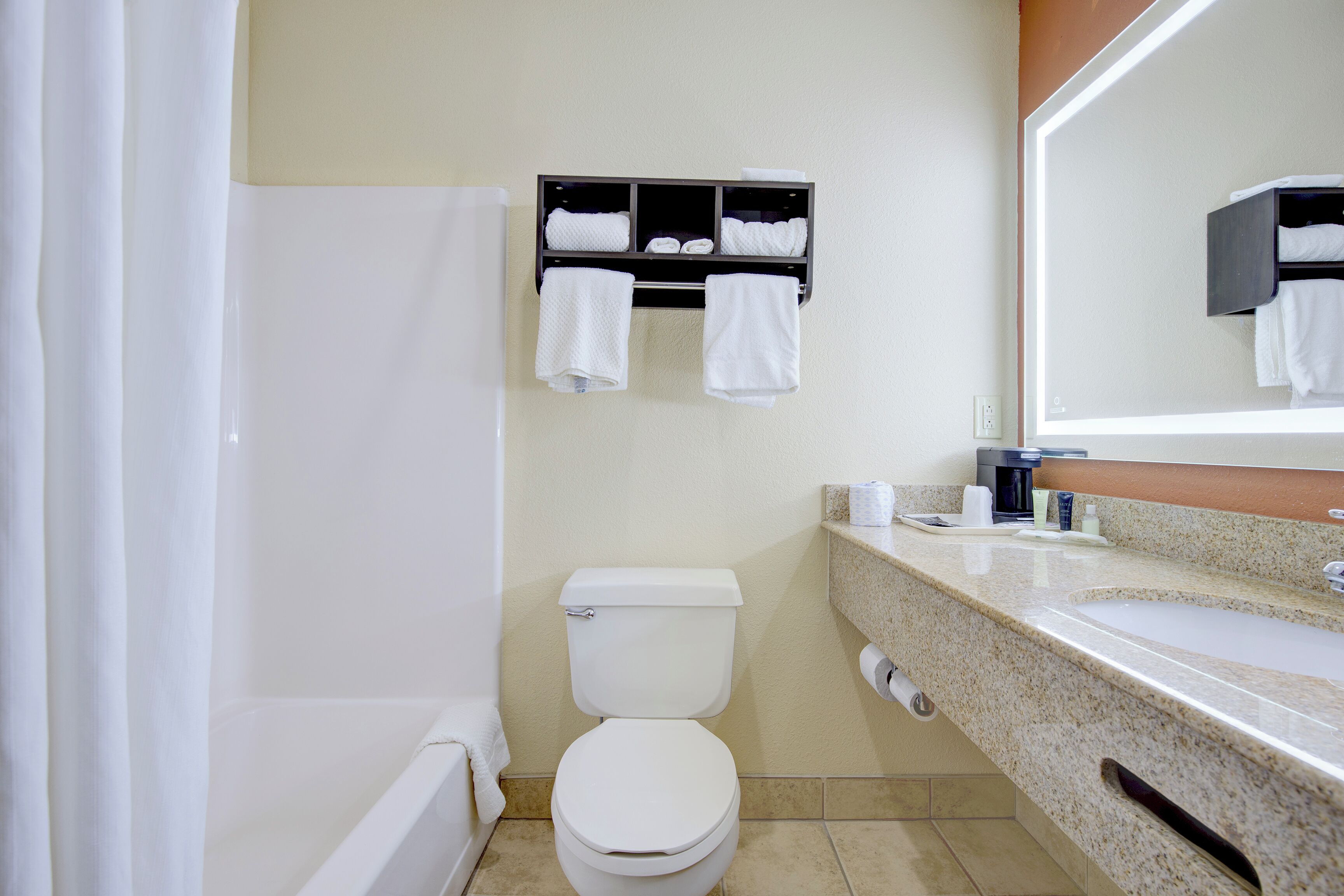 A bathroom with a toilet, a sink, a towel rack, and a shower.