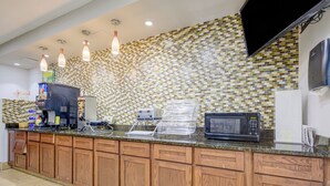 A kitchen with a coffee machine, toaster, and microwave on the counter. - Saint Joseph Inn & Suites Benton Harbor Near I-94 (Benton Harbor)