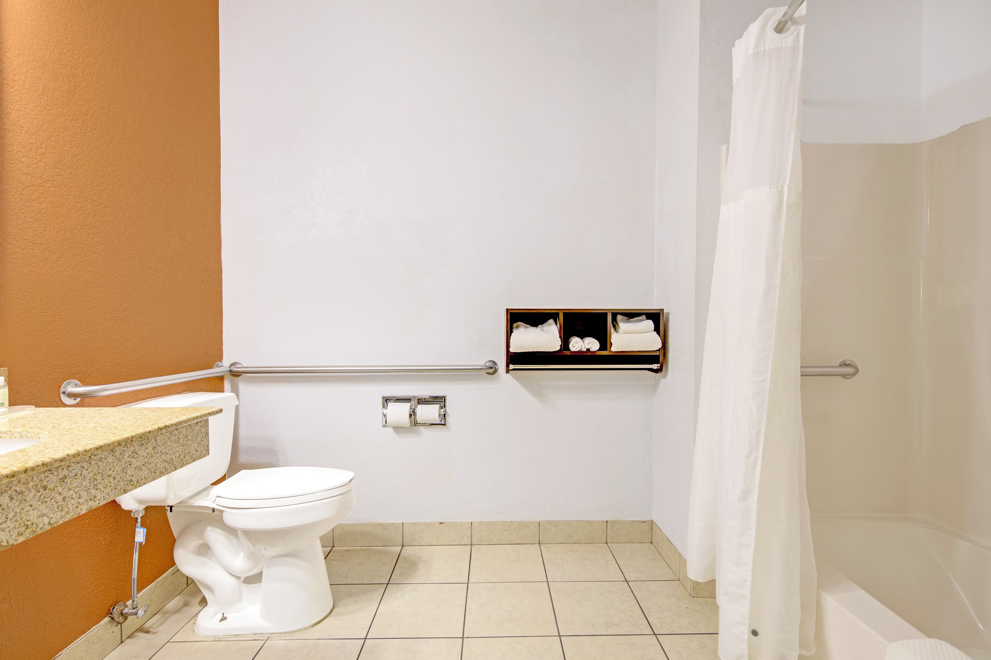 Ein Badezimmer mit Toilette, Handtuchhalter und Duschvorhang.