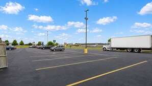 A parking lot with marked spaces, a large truck, and a clear sky. - Saint Joseph Inn & Suites Benton Harbor Near I-94 (Benton Harbor)