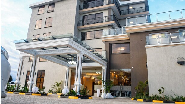 Un hôtel à plusieurs étages doté d’une entrée couverte, d’un espace extérieur aménagé et d’une architecture moderne.
