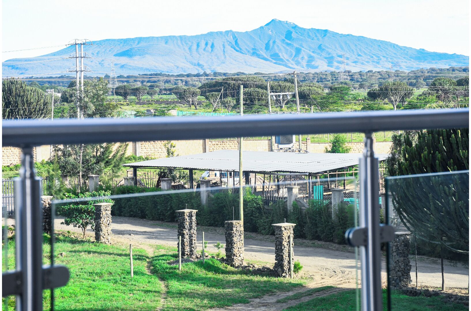 Un paisaje montañoso con un edificio que tiene techo de metal y pilares de piedra.