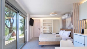A modern bedroom with a bed, bedside tables, a TV, and a built-in wardrobe. - Assini Estate - Pet Friendly Studio With Pool (Pylos-Nestoras)