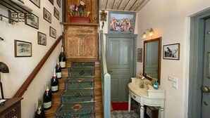 Una scala con tappeto decorato, una porta di legno, uno specchio e un lavandino.