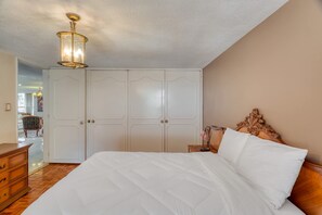 Ein Schlafzimmer mit einem großen Bett, einer Holzkommode, einem Nachttisch und einem Kleiderschrank.