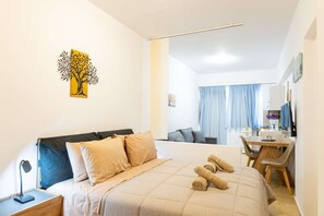 Ein Hotelzimmer mit einem Bett, einem Schreibtisch, einem Sessel, einer Lampe und einem Bild an der Wand.