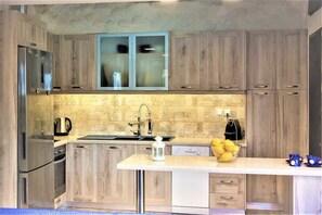 A modern kitchen with wooden cabinets, stainless steel appliances, and a central island.