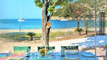 Mesa lista para comer con vista al mar y barcos.