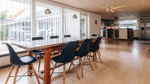 Een ruime keuken met een houten plafond, grote ramen en een centraal eiland.